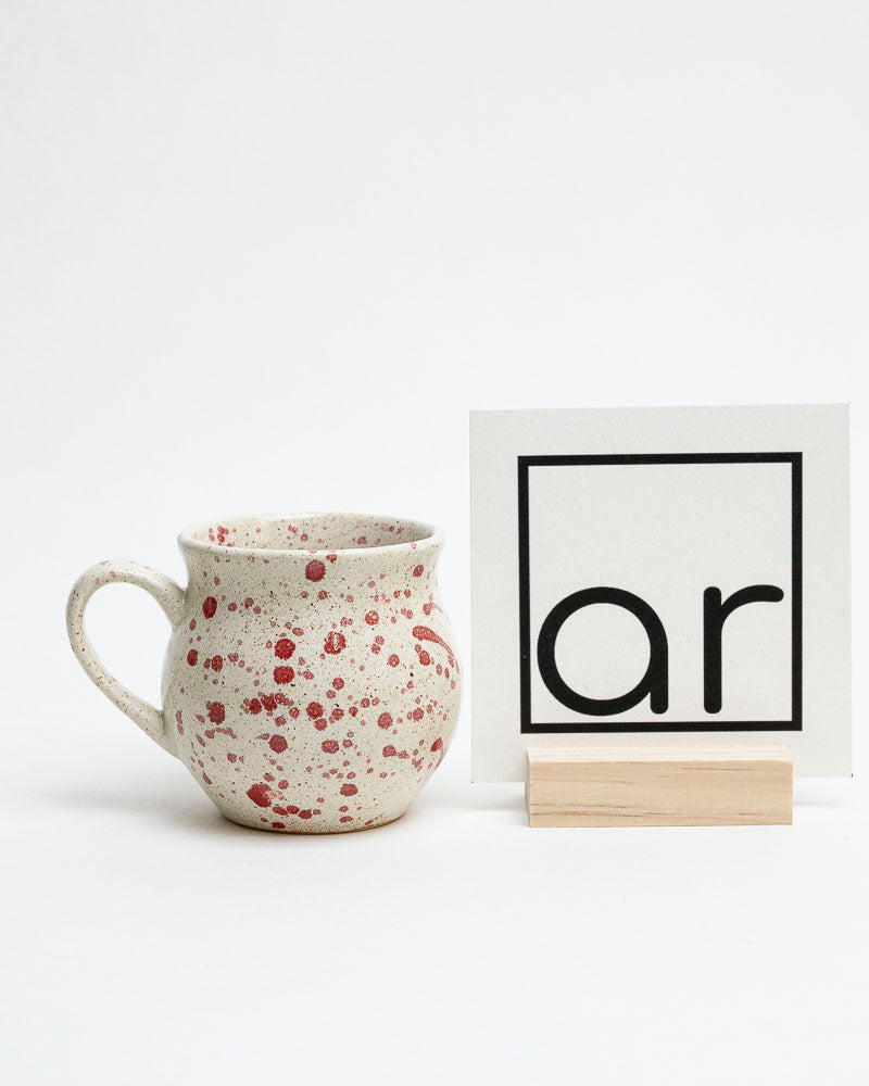 Kubek śmietankowy z czerwonymi piegami